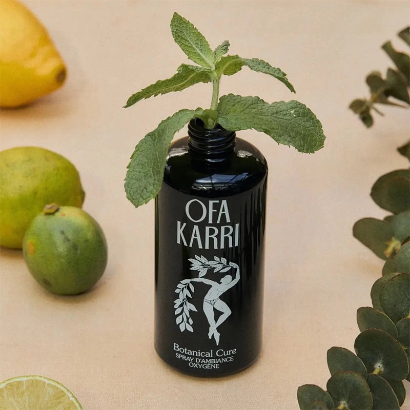 Lifestyle shot of Ofa Karri Botanical Cure Home Spray (200 ml) with top off and mint placed in bottle