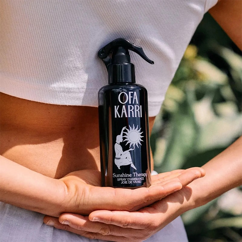 Model holding Ofa Karri Sunshine Therapy Home Spray (200 ml) behind her back