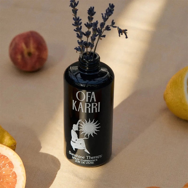 Lifestyle shot of Ofa Karri Sunshine Therapy Home Spray (200 ml) with top off and lavender placed in bottle