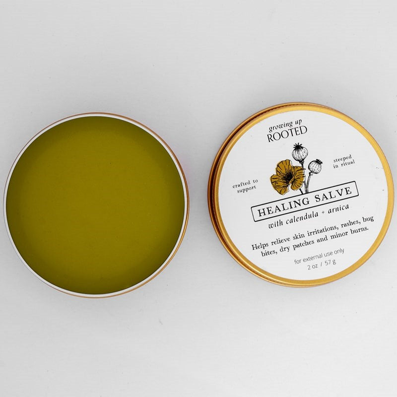 Growing Up Rooted Healing Salve - product shown opened next to lid