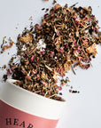 Growing Up Rooted Heart Loose Leaf Herbal Tea - product shown pouring out of packaging shown