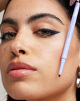 Kosas Soulgazer Eyeliner - Enigma - model shown wearing product and holding it