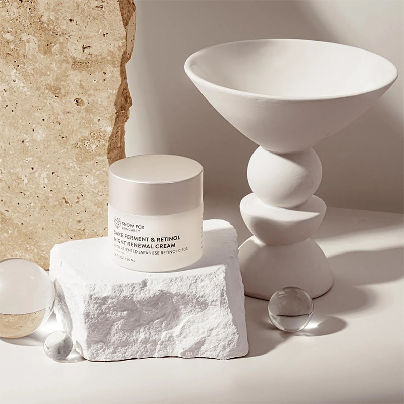 Snow Fox Skincare Sake Ferment & Retinol Night Renewal Cream - product shown next to stones and glass