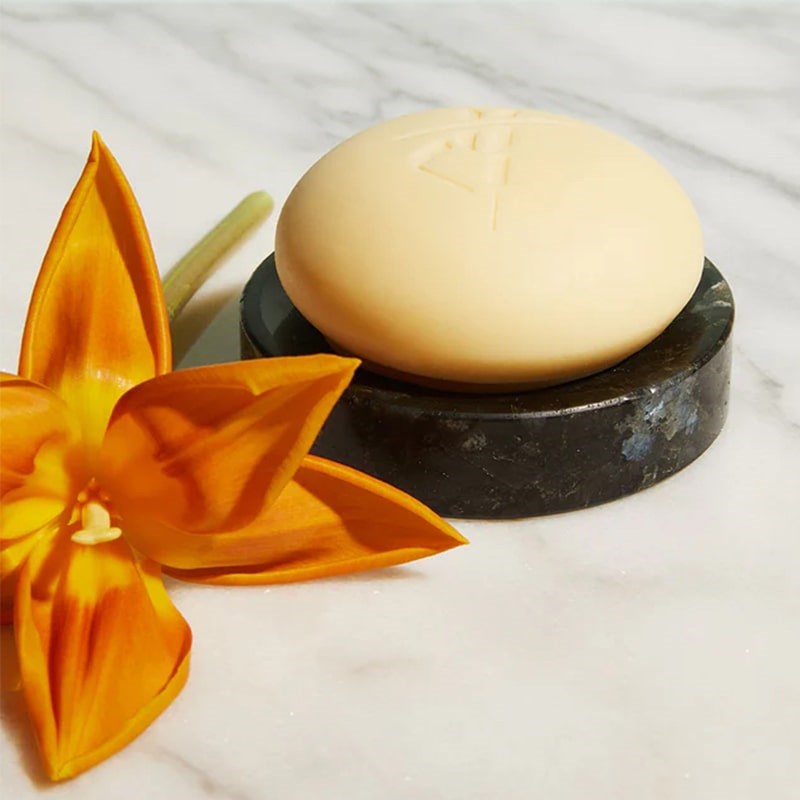 Kate McLeod The Granite Dish - product shown with lotion bar on it next to flower