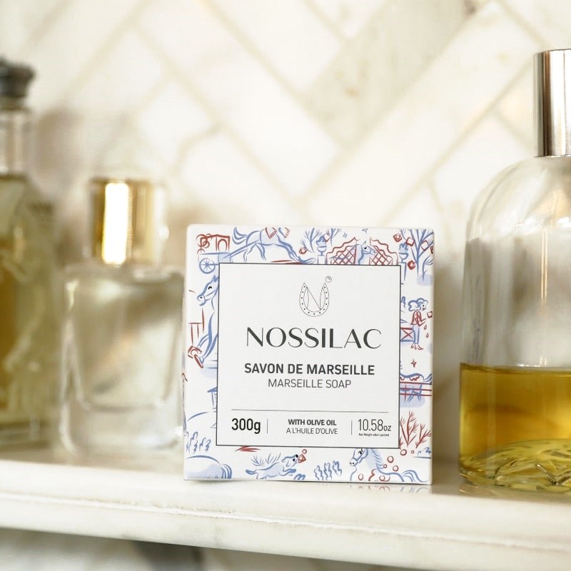 Nossilac Authentic Marseille Soap Cube - product packaging shown on shelf with bottles