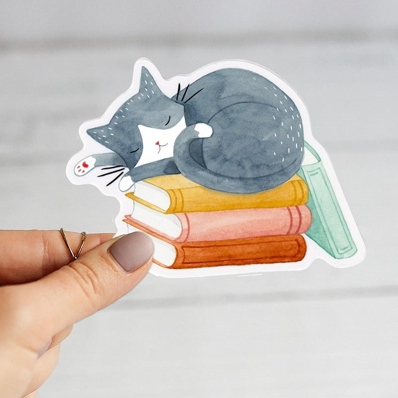 Julianna Swaney Cat and Books Sticker - model shown holding product