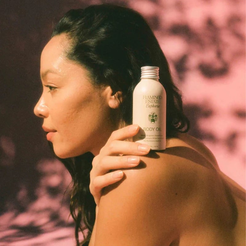 Flamingo Estate Organics Damask Rose & Bergamot Body Oil - model shown holding product on shoulder