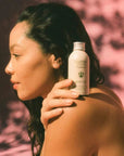 Flamingo Estate Organics Damask Rose & Bergamot Body Oil - model shown holding product on shoulder